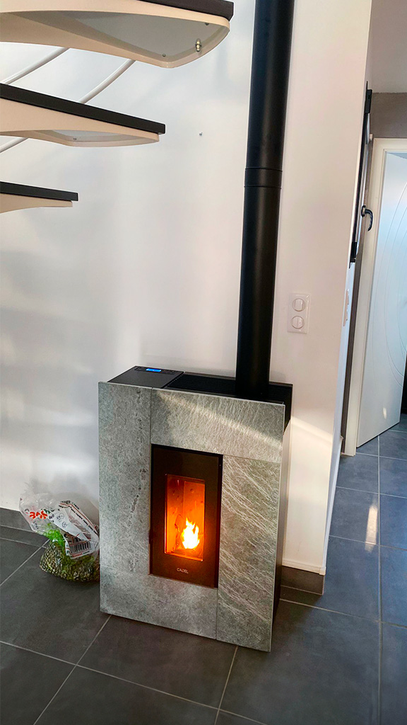 Pelletskamin Grace 7 kW med täljstensfront installerad i hem, effektiv pelletskamin med värmelagrande sten.